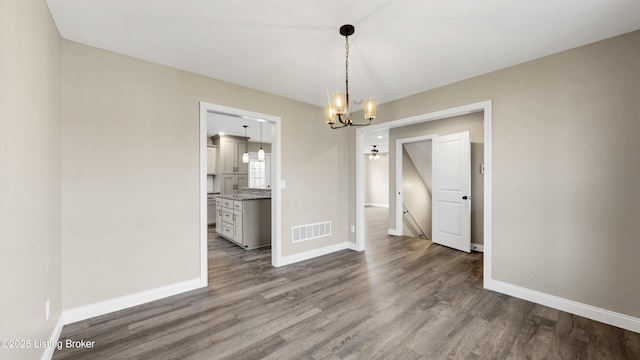 389 Williamsburg Dr, Mt Washington, KY 40047 - unfurnished dining area with wood finished floors, a notable chandelier, baseboards, and visible vents