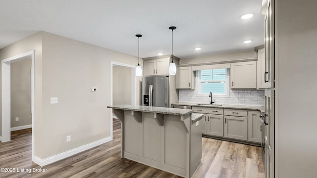 389 Williamsburg Dr, Mt Washington, KY 40047 - kitchen with stainless steel fridge, baseboards, a sink, light wood-style floors, and backsplash
