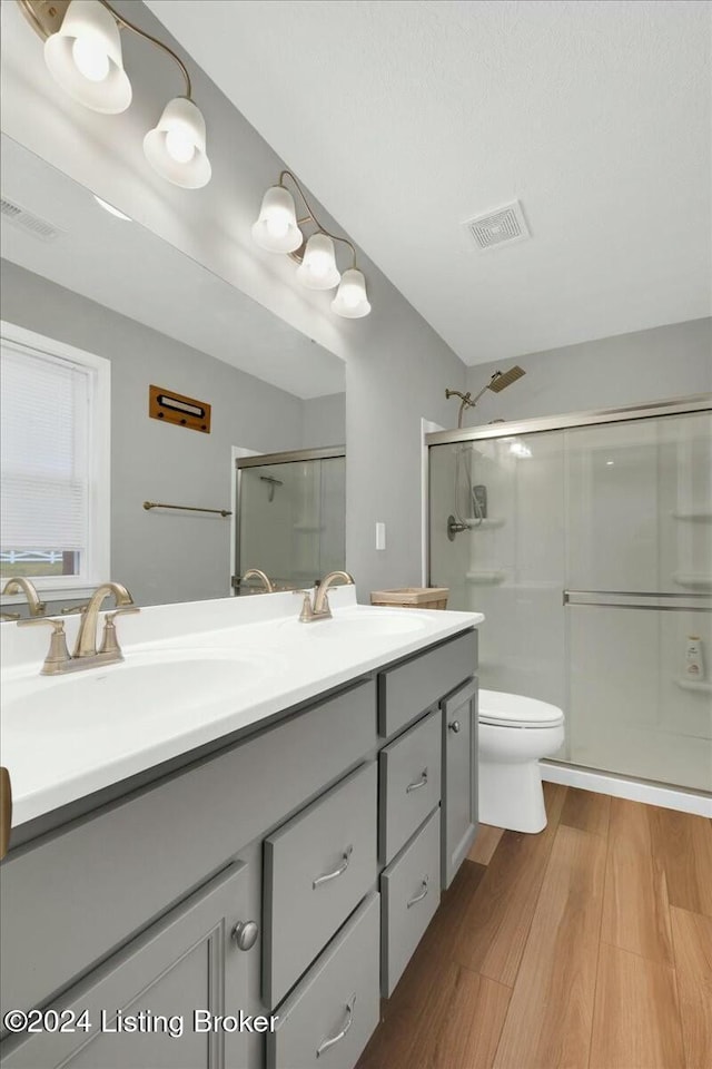 bathroom featuring vanity, toilet, an enclosed shower, and wood-type flooring