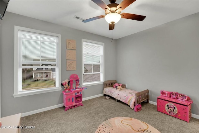 carpeted bedroom featuring ceiling fan and multiple windows