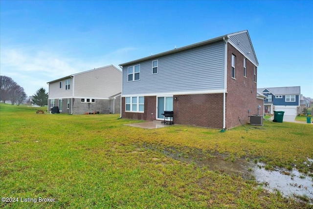 rear view of house with cooling unit, a patio area, and a lawn