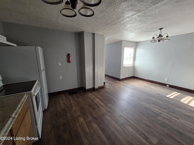 kitchen featuring dark wood-type flooring, decorative light fixtures, electric range, a textured ceiling, and a notable chandelier