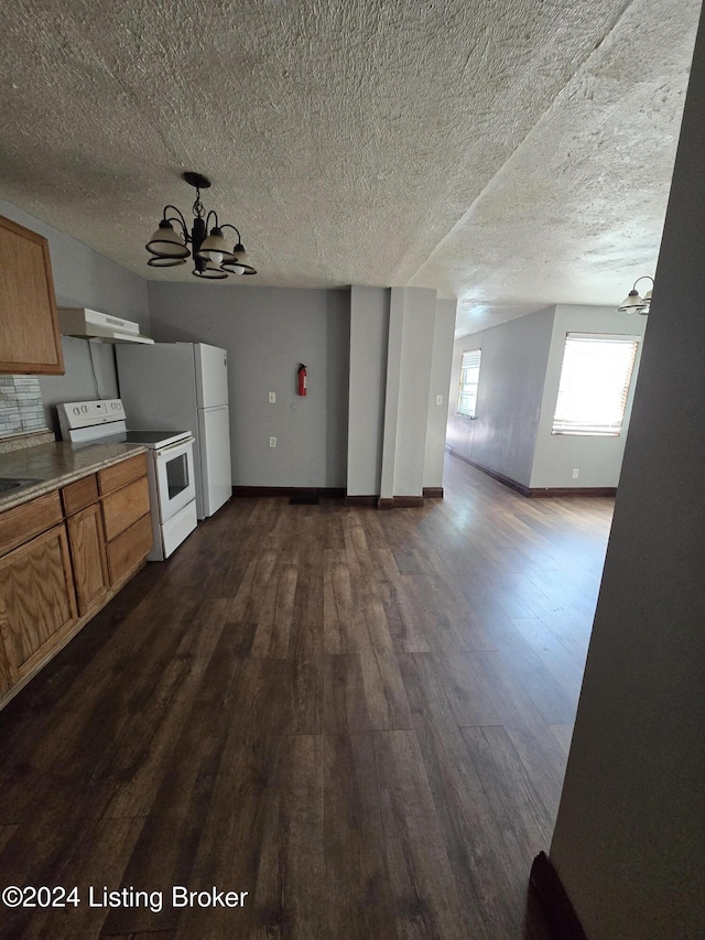 kitchen with a textured ceiling, white appliances, dark hardwood / wood-style floors, and a notable chandelier