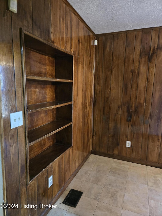 interior details with a textured ceiling and wood walls