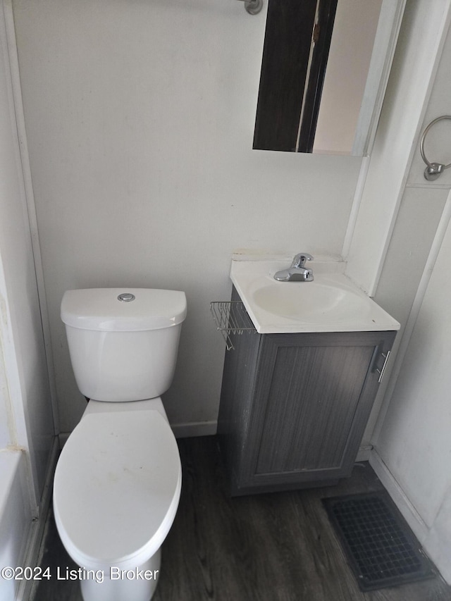 bathroom with hardwood / wood-style floors, vanity, and toilet