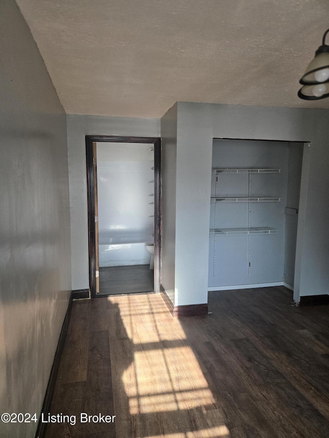 interior space featuring dark hardwood / wood-style flooring, a closet, and connected bathroom