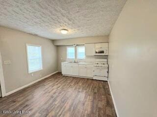 kitchen featuring a textured ceiling, stove, white cabinetry, and dark wood-type flooring