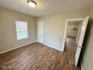 unfurnished bedroom with dark hardwood / wood-style flooring