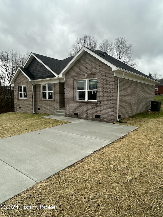 single story home with cooling unit and a front yard