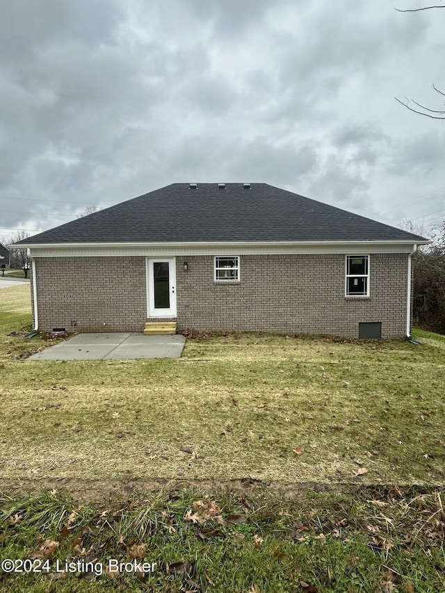 rear view of property with a yard and a patio