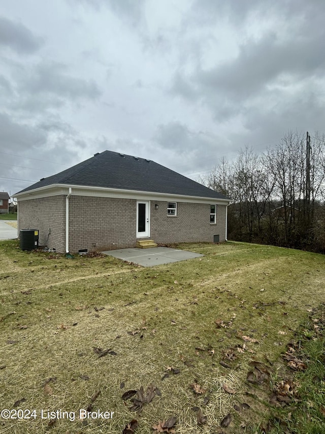 back of house featuring a lawn, a patio, and central AC unit