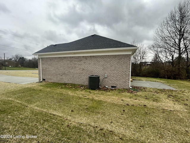 view of side of home with a lawn and central AC