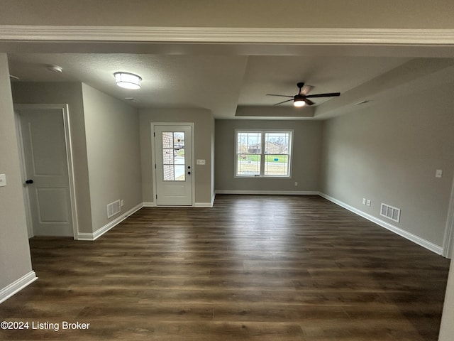 interior space featuring ceiling fan, dark wood-type flooring, and a textured ceiling