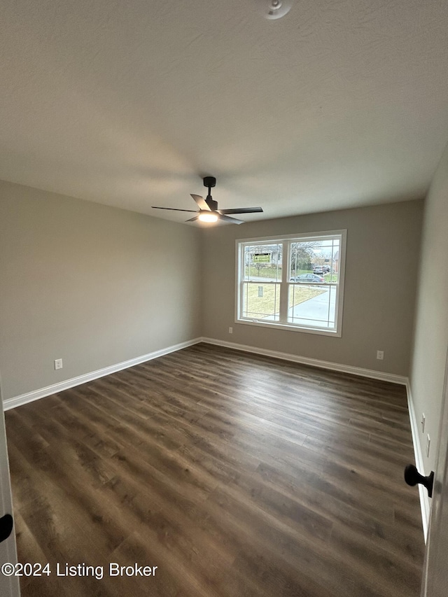 empty room with ceiling fan and dark hardwood / wood-style floors