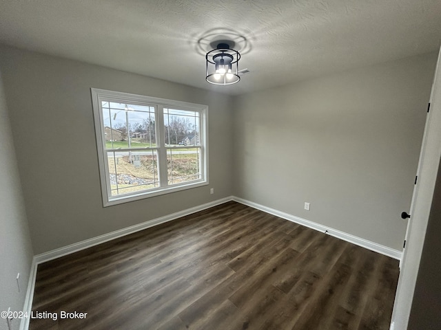 unfurnished dining area with a textured ceiling and dark hardwood / wood-style floors