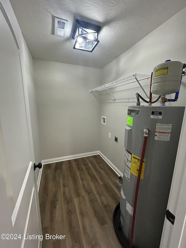 clothes washing area featuring hookup for an electric dryer, washer hookup, electric water heater, a textured ceiling, and dark wood-type flooring