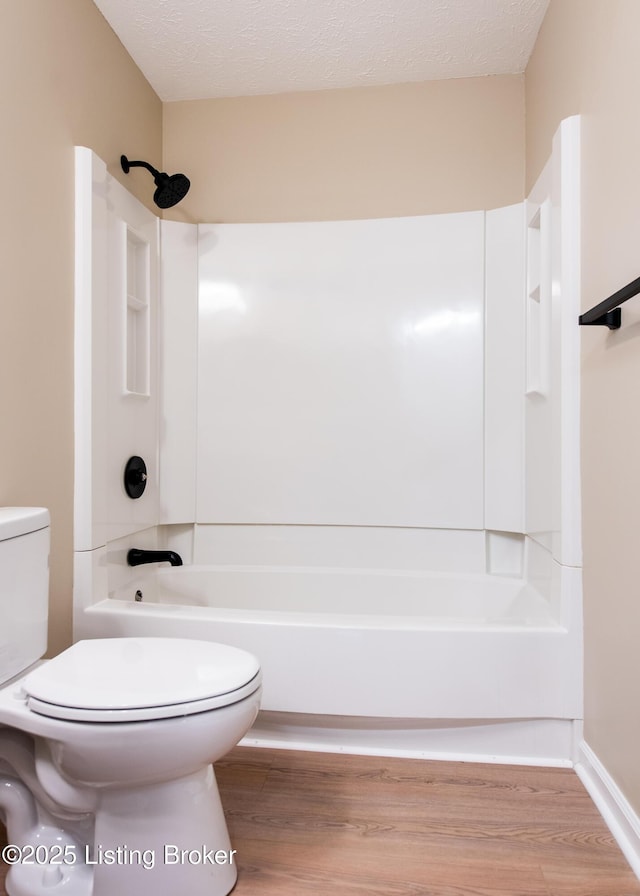 bathroom with a textured ceiling, hardwood / wood-style flooring, and toilet