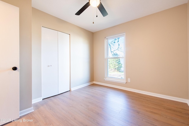 unfurnished bedroom featuring ceiling fan, light wood-type flooring, and a closet