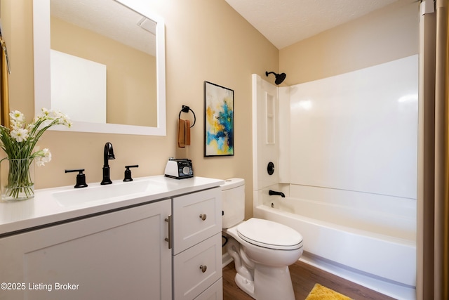 full bathroom with a textured ceiling, vanity, bathing tub / shower combination, hardwood / wood-style flooring, and toilet