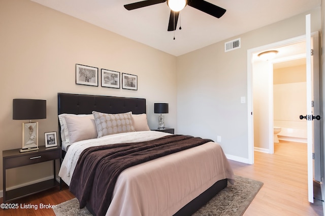 bedroom featuring ceiling fan, ensuite bathroom, and light wood-type flooring