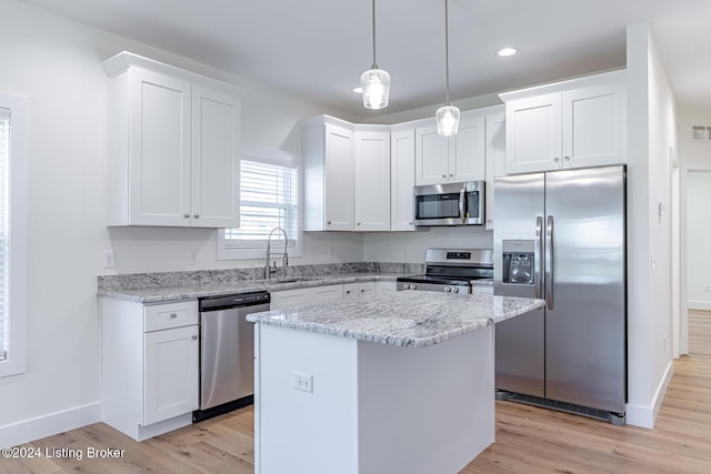 kitchen featuring sink, stainless steel appliances, a kitchen island, light hardwood / wood-style floors, and white cabinets