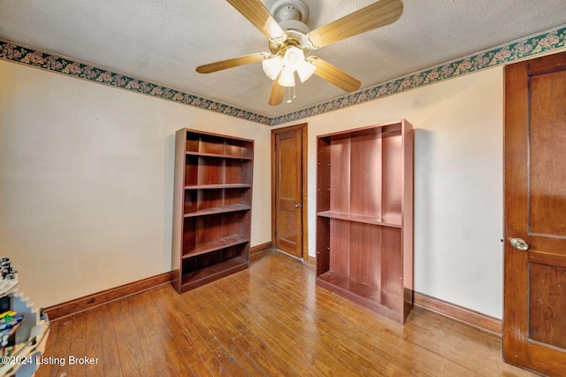 unfurnished bedroom with a textured ceiling, a closet, light hardwood / wood-style flooring, and ceiling fan