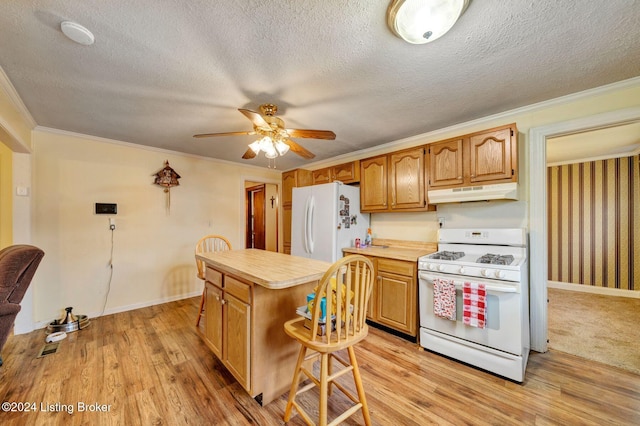 kitchen featuring a center island, white appliances, ornamental molding, and light hardwood / wood-style flooring