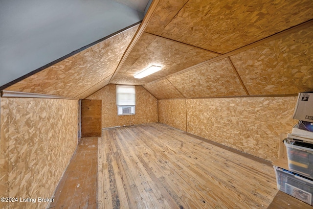 additional living space with wood-type flooring and lofted ceiling