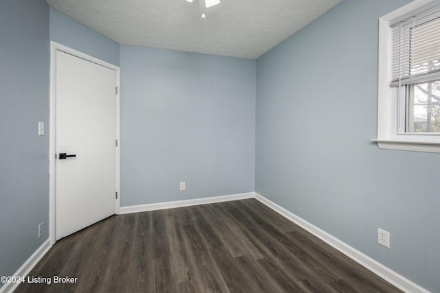 spare room featuring dark hardwood / wood-style flooring and a textured ceiling