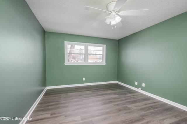 empty room with ceiling fan, a textured ceiling, and light wood-type flooring