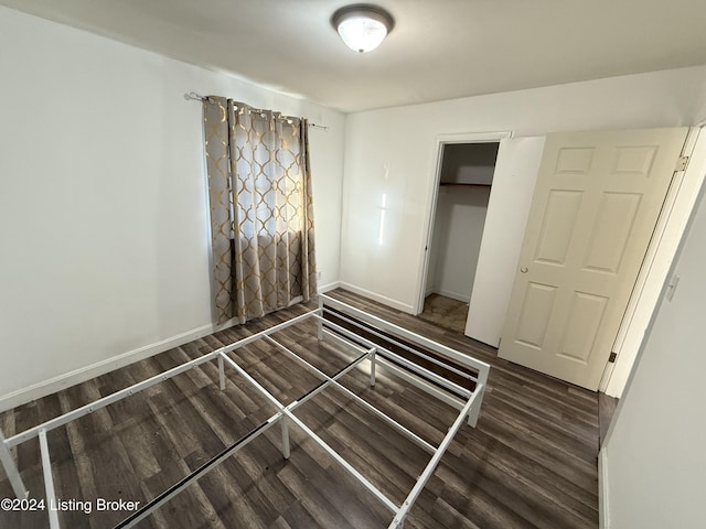 unfurnished bedroom featuring dark hardwood / wood-style flooring and a closet