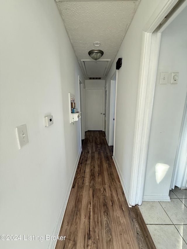 hallway with wood-type flooring and a textured ceiling