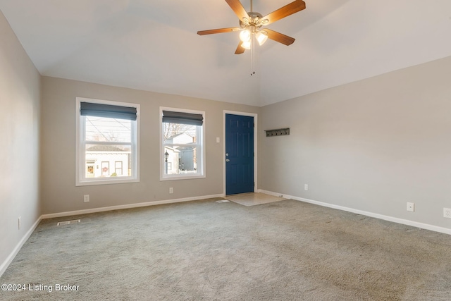 empty room featuring ceiling fan, carpet flooring, and vaulted ceiling