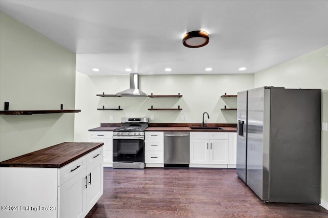 kitchen with wall chimney exhaust hood, white cabinetry, sink, and appliances with stainless steel finishes