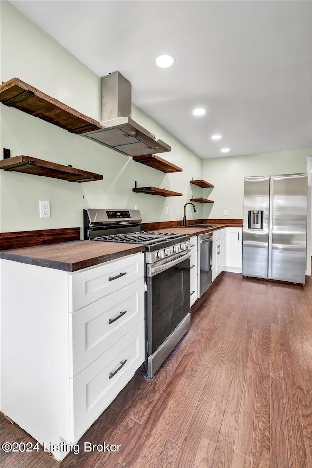 kitchen featuring appliances with stainless steel finishes, island range hood, white cabinetry, and dark hardwood / wood-style floors