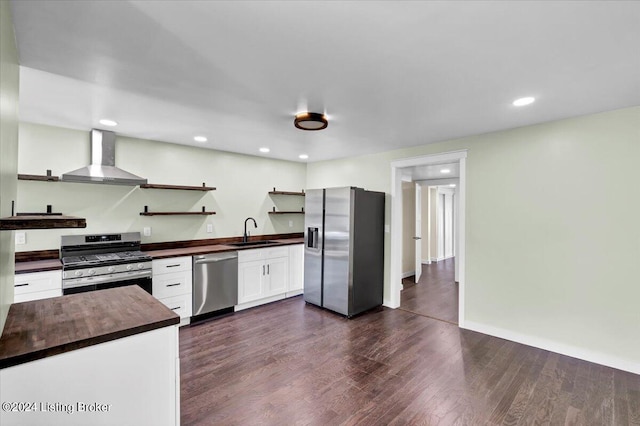 kitchen with white cabinetry, sink, wall chimney exhaust hood, dark hardwood / wood-style floors, and appliances with stainless steel finishes