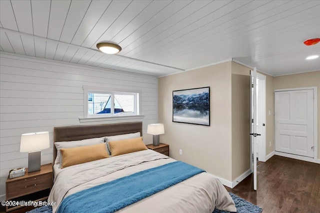 bedroom featuring dark hardwood / wood-style flooring, wooden walls, and wooden ceiling