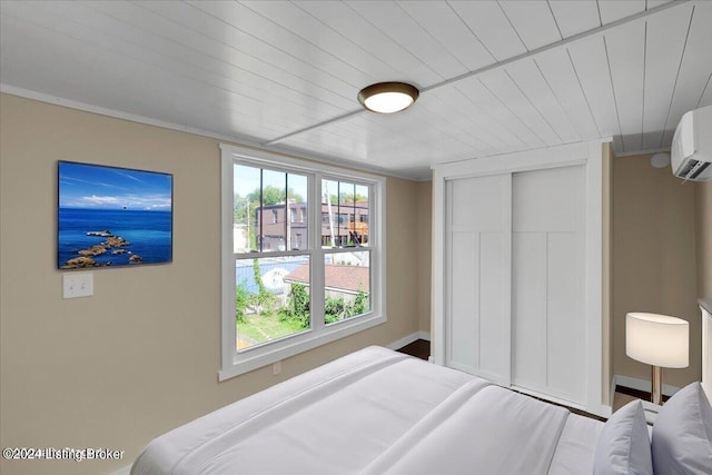 bedroom featuring an AC wall unit and a closet