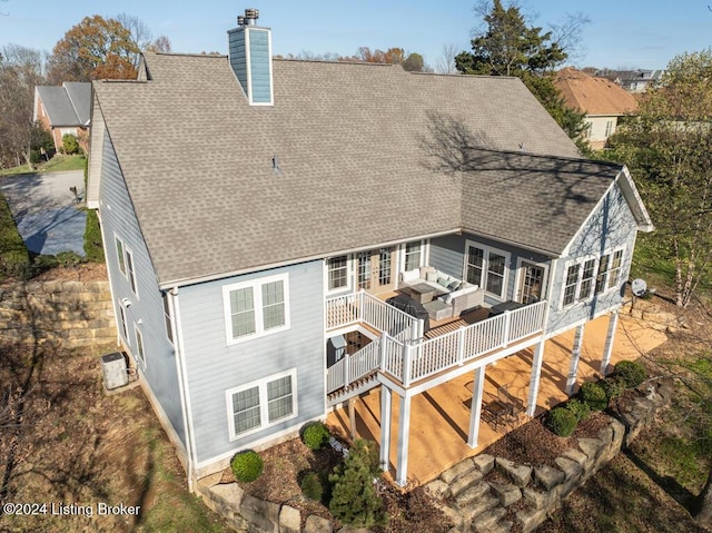 back of house with outdoor lounge area and a deck