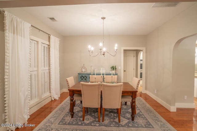 dining space featuring hardwood / wood-style flooring and a notable chandelier