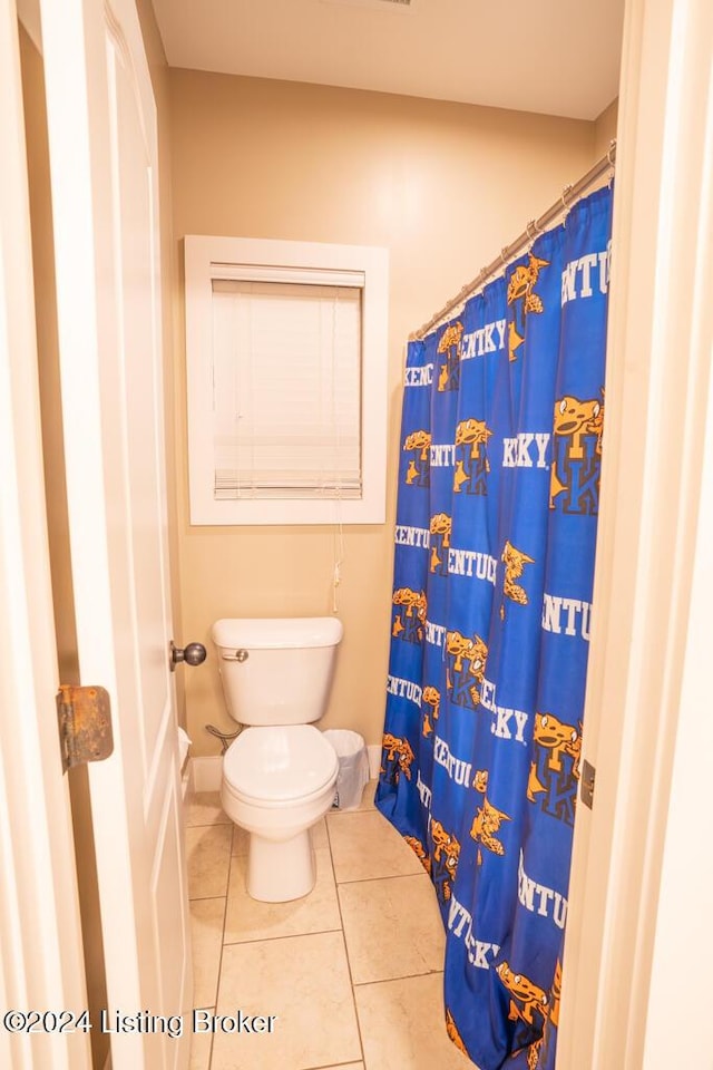 bathroom featuring tile patterned floors, a shower with shower curtain, and toilet