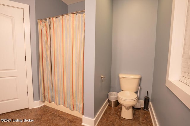 bathroom with a shower with shower curtain and toilet