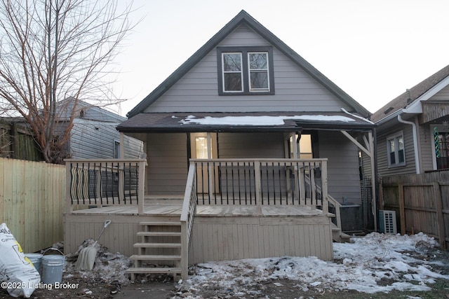 snow covered house featuring a porch