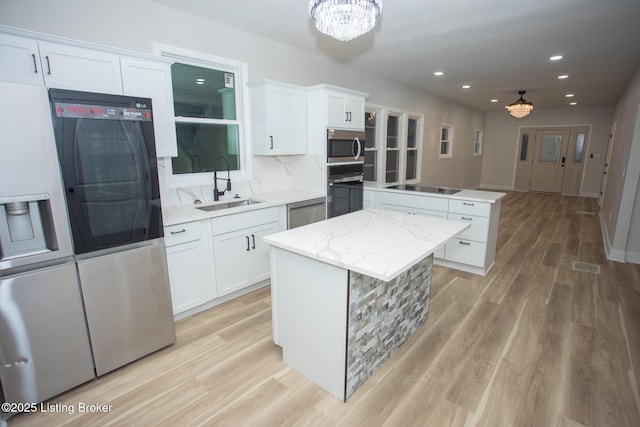 kitchen featuring sink, a center island, and white cabinets