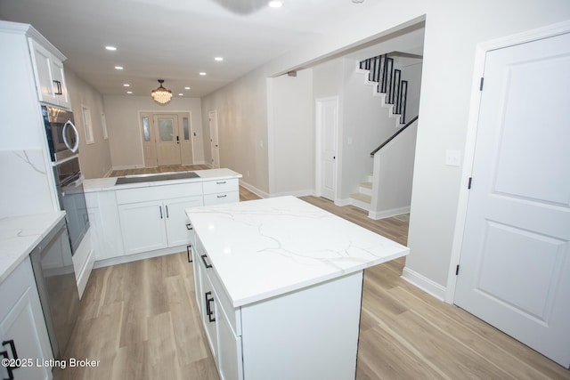 kitchen featuring a kitchen island, appliances with stainless steel finishes, and white cabinets