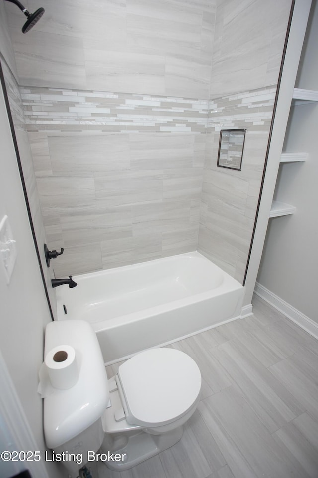 bathroom with tiled shower / bath combo and toilet