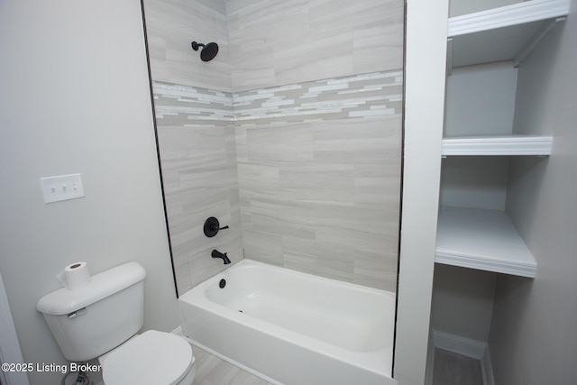 bathroom featuring toilet and tiled shower / bath