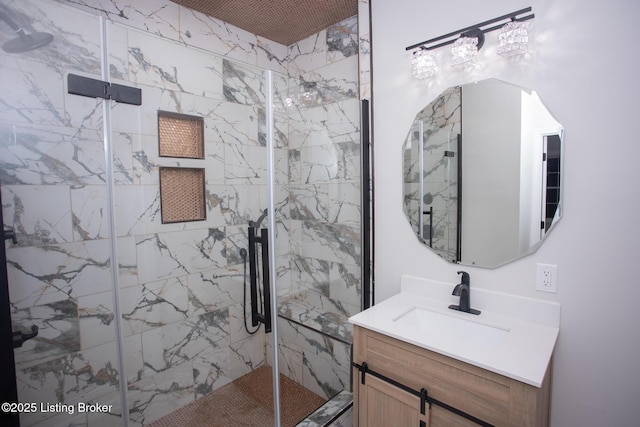 bathroom featuring a shower with door and vanity