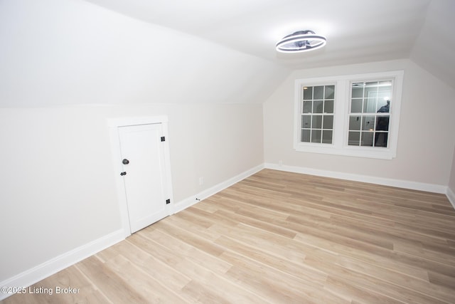 additional living space with vaulted ceiling and light hardwood / wood-style floors