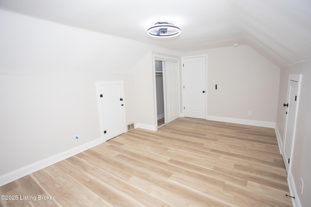 additional living space with lofted ceiling and light wood-type flooring